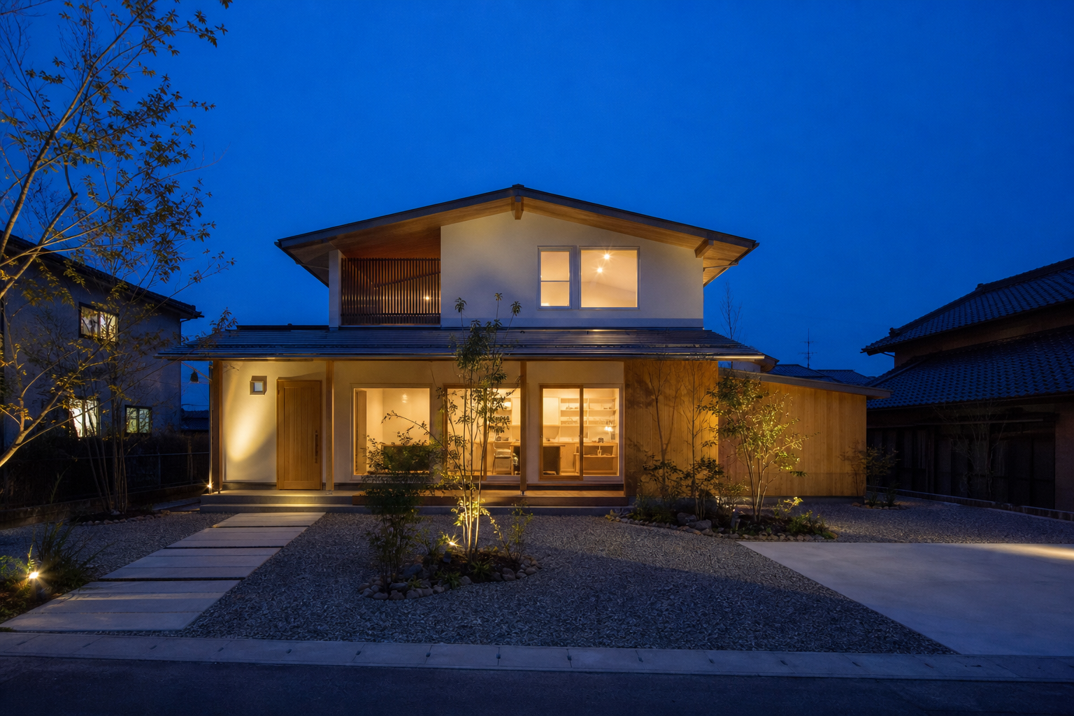 夕暮れ時に室内の明かりが灯る木造住宅の外観建築写真